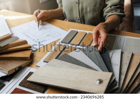 interior designer working on new house design project in office. choosing flooring and furniture materials and colors from samples