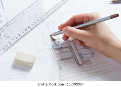 Interior designer works on a hand drawing sketch using color pencils, rule and rubber