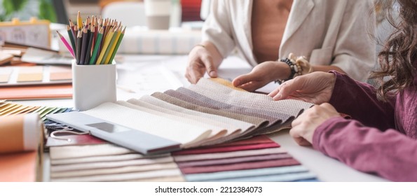 Interior designers working together on a project in their office: they are checking fabric samples and picking the right color palette, hands close up - Powered by Shutterstock