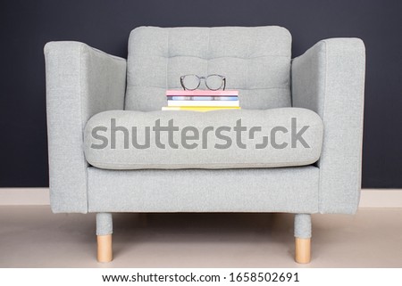 interior design,light gray sofa with books on dark wall. waitingroom seat