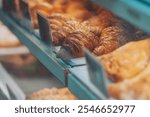 Interior details at the bakery and coffee shop. Bistro showcase with shelves of freshly croissants and bread in assortment. Zero waste shop or sustainable local small businesses at food service. 