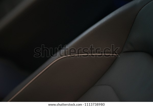 Interior\
details of a modern car close-up. Stylish beautiful black seats in\
the car. Car design and interior decoration close-up. Soft focus\
and beautiful bokeh, little depth of\
field.