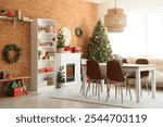 Interior of dining room with table, fireplace and Christmas trees