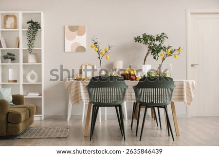 Interior of dining room with table setting, fresh citruses and lemon tree branches