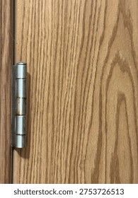 Interior door hinge hardware mounted on wooden door frame showing residential construction detail.