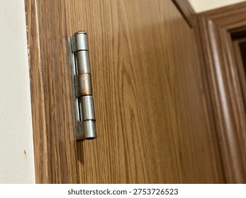 Interior door hinge hardware mounted on wooden door frame showing residential construction detail.