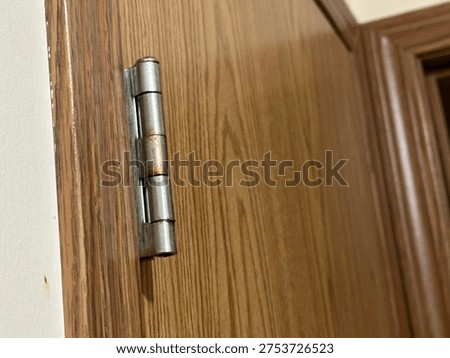 Interior door hinge hardware mounted on wooden door frame showing residential construction detail.