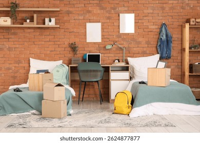 Interior of dorm room with beds, table and moving boxes
