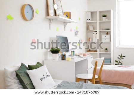 Interior of dorm room with beds, table and sticky notes