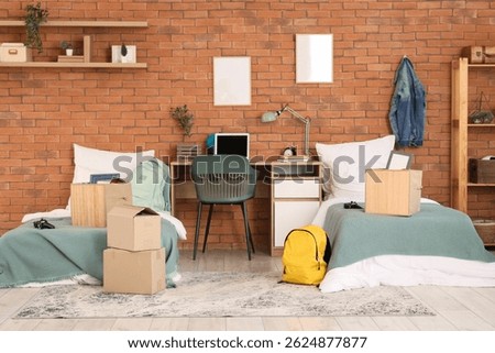 Interior of dorm room with beds, table and moving boxes