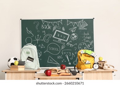 Interior of empty classroom with desks, school accessories and chalkboard