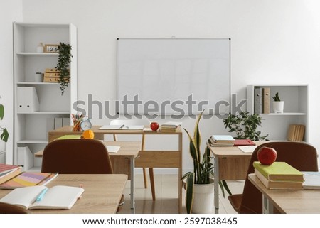 Interior of empty classroom with school desks and clean whiteboard