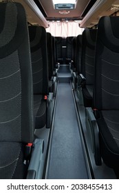 Interior Of Empty Clean Bus Aisle With Rows Of Black Cloth Seats