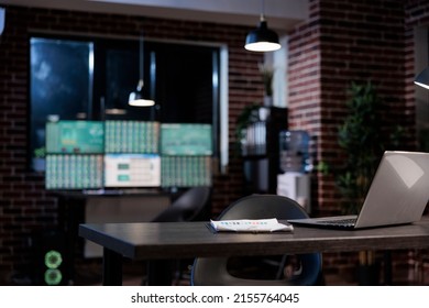 Interior Of Empty Forex Stock Market Workspace With Desk Having Modern Laptop Computer On Top. Exchange Company Office With Nobody In It And Multiple Monitors Workstation.