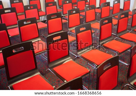 Interior of empty modern meetingroom. Conference room in a hotel for business training. Rows of chairs and desks. Boardroom with presentation screen and projector.

