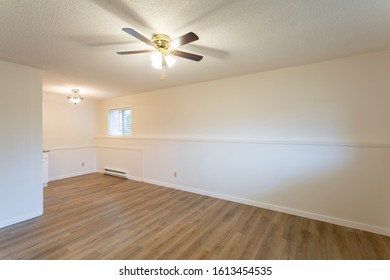 Interior Of Empty Renovated Apartment Condo Rental Unit With White Walls And New Hard Wood Vinyl Laminate Flooring.