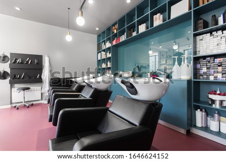 Interior of european beauty salon. Hairdresser places and many professional cosmetics on shelves