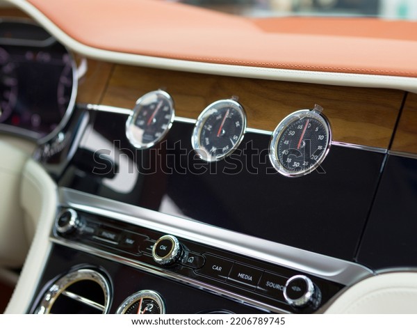 interior of an expensive car with a designer clock\
on the control panel