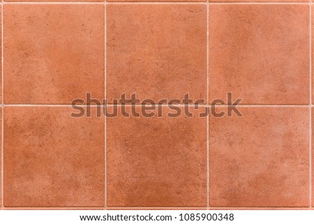 Interior or exterior bathroom or kitchen square ceramic tiles. Image of interior flooring with red orange pavement slabs.