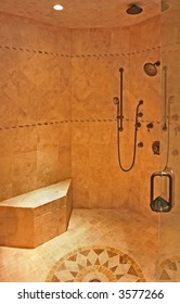 An Interior Of A Fancy Shower Stall With Seating And Multiple Shower Heads.