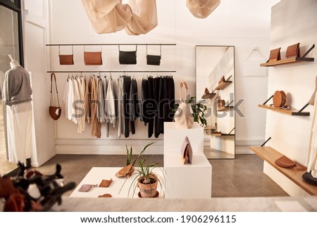 Interior of a fashionable clothing boutique full of an assortment of bags and accessories on display