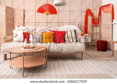 Interior of festive living room with traditional Chinese decorations, white sofa and wooden coffee table. Chinese New Year celebration