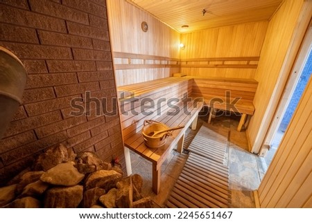 Interior of Finnish sauna, classic wooden sauna with hot steam. Relax in hot sauna with steam. Wooden interior baths, wooden benches and loungers accessories for sauna, spa complex.