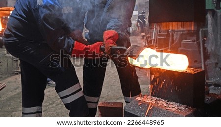 The interior of the forge. Blacksmiths during the process of forging iron. Forging of steel parts.