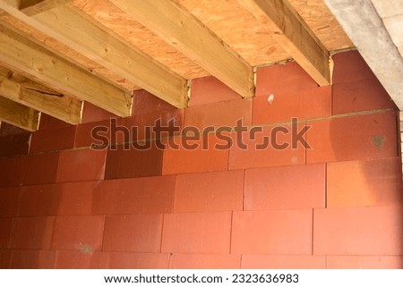 Interior garage in construction. Span flat roof supported by supporting beams in wood. Expanding foam filling the gaps in the flat roof with wall connection