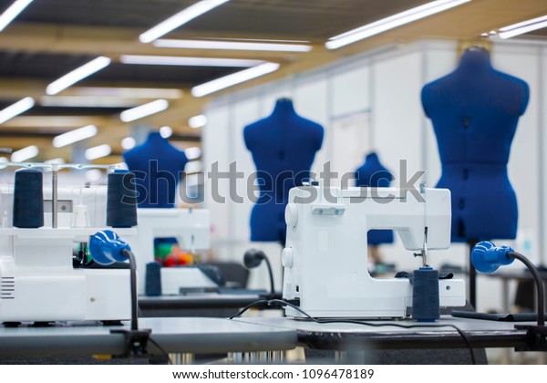 Interior of garment factory . Closes making\
atelier with several sewing machines. Tailoring industry, fashion\
designer workshop, industry\
concept