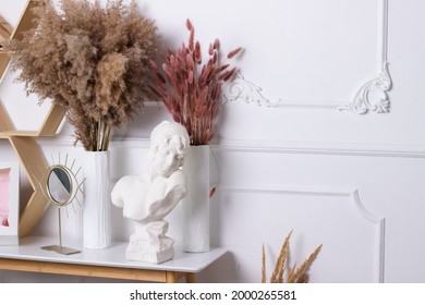 Interior greek statue of a woman on the background of a white wall with a white frame with dry flowers in a vase minimalistic modern interior mirror eyes ikea