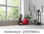 Interior of gym with fitball, fitness mats and exercising machine