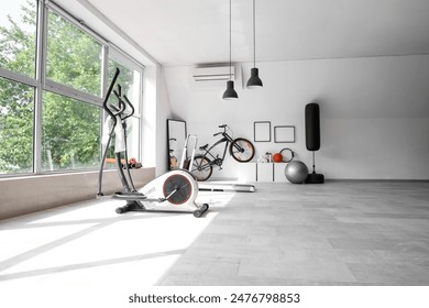 Interior of gym with sports equipment, bicycle and mirror - Powered by Shutterstock