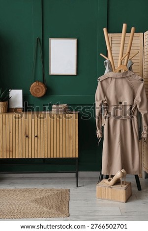 Interior of hall with commode, coat rack and blank frame