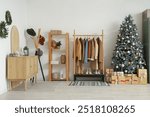 Interior of hallway with Christmas tree, coat rack and drawers