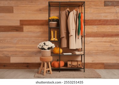 Interior of hallway with chrysanthemum flowers, coat rack and pumpkins - Powered by Shutterstock