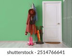 Interior of hallway with door, umbrellas and coat rack