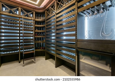 The interior of a home wine cellar with a stepladder at the rack with shelves. Glasses for tasting.