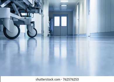 An interior of a hospital hallway with a stretchers wheels