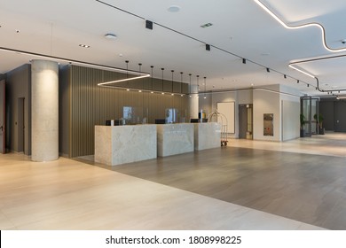 Interior of a hotel lobby with reception desks with transparent covid plexiglass lexan clear sneeze guards - Shutterstock ID 1808998225