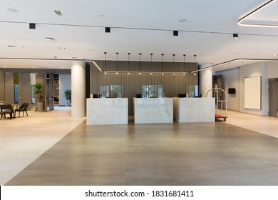 Interior of a hotel lobby with reception desks with transparent coronavirus guards - Shutterstock ID 1831681411