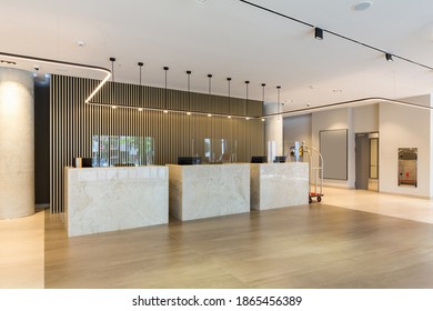 Interior of a hotel lobby with reception desks with transparent coronavirus guards