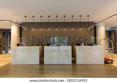 Interior of a hotel lobby with reception desks with transparent covid plexiglass lexan clear sneeze guards