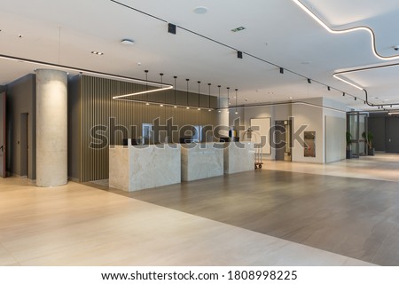 Interior of a hotel lobby with reception desks with transparent covid plexiglass lexan clear sneeze guards