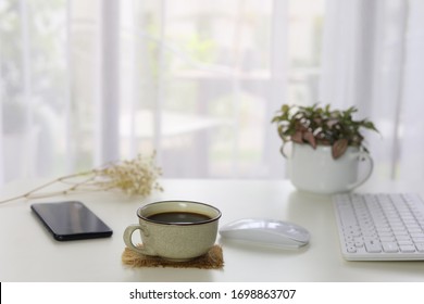 Interior House Modern Decor With Smartphone Coffee And White Keaboard And Mouse And Plants Pot With See Through Curtain  
