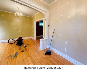 Interior of a house under renovation. Cleaning the wall with a broom in an apartment bedroom.