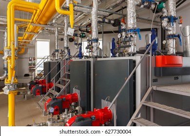 Interior of industrial gas boiler house with many pipes and boilers.