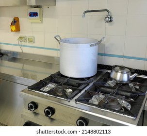 interior of an industrial kitchen with the large aluminum pot above the stove and a teapot for the preparation of infusions and a scale for weighing
