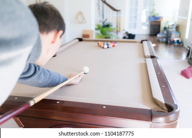 Interior Inside House Home With Billiard Pool Table In Living Room, Young Man In Winter Cold Sweater Shooting White Ball During Game Start With Cue