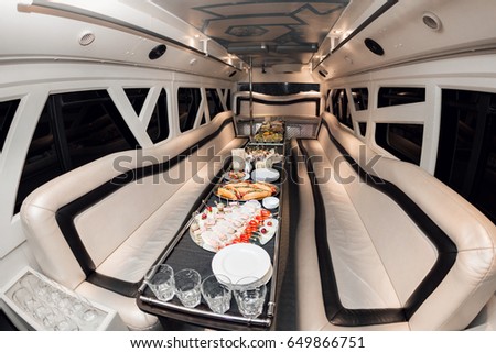 Interior inside the limousine. with sofas and a table covered with snacks for the holiday. Selective focus